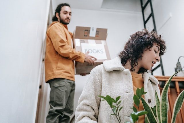 tenants moving into an apartment holding boxes labeled books