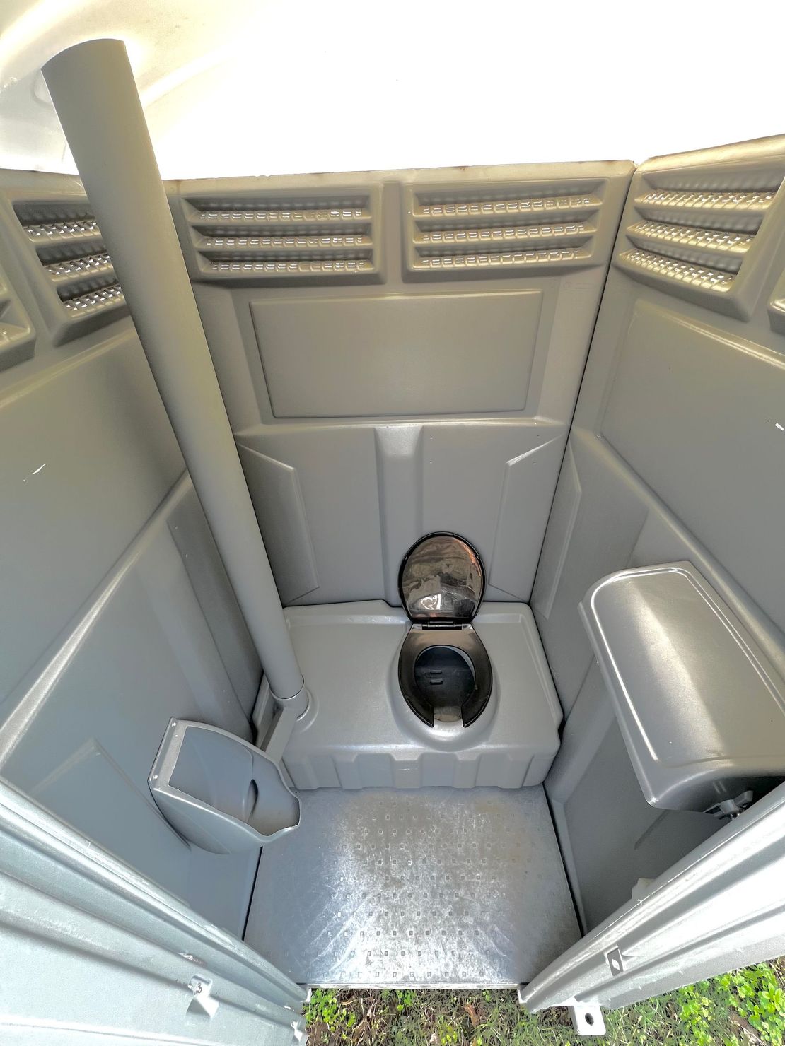 The inside of a portable toilet with the door open