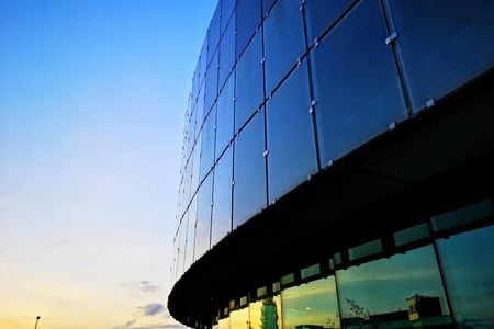 A large building with a lot of windows and a blue sky in the background.