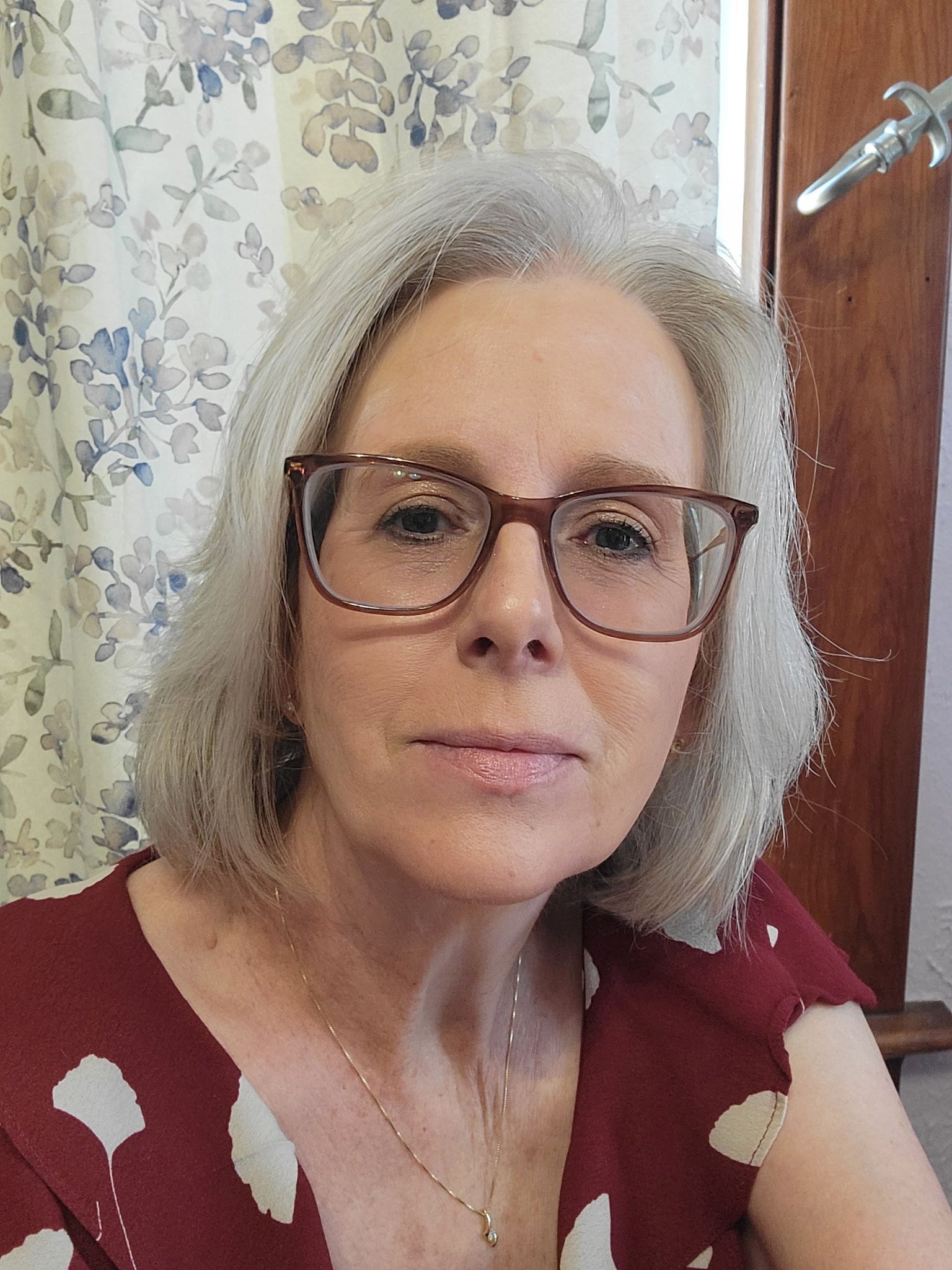 Wendy Wesolowski wearing glasses and a white shirt in an indoor setting.
