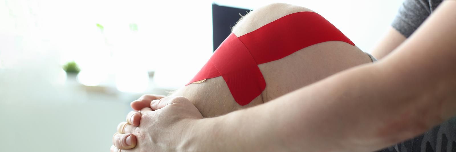A person is holding a red and white pillow on their lap.