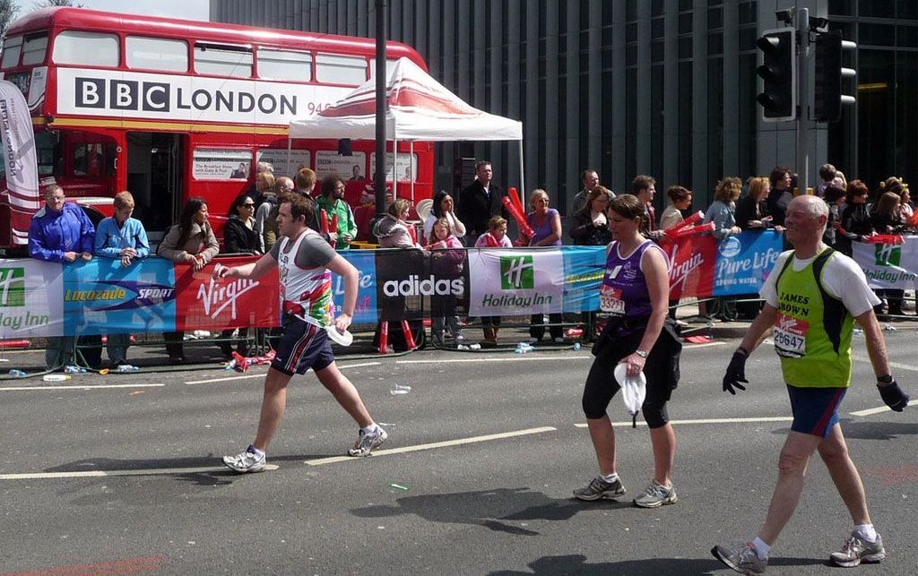 A bbc london bus is parked on the side of the road during the London Marathon
