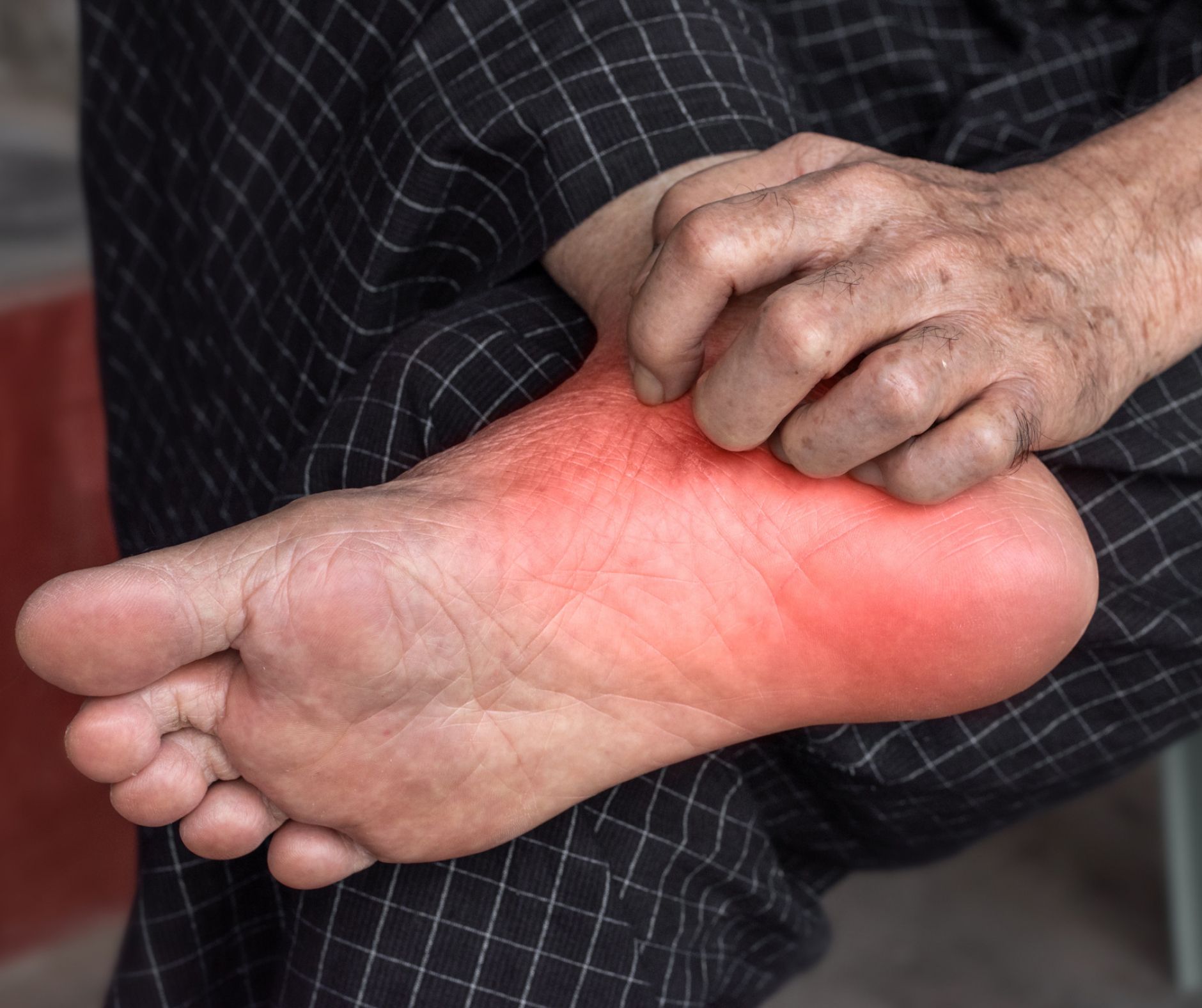 A person is holding their sore foot.