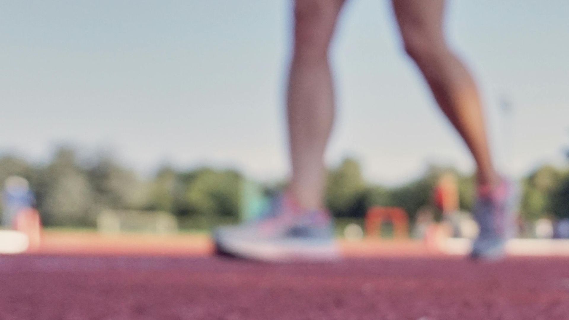 A woman is running on a track in a park.