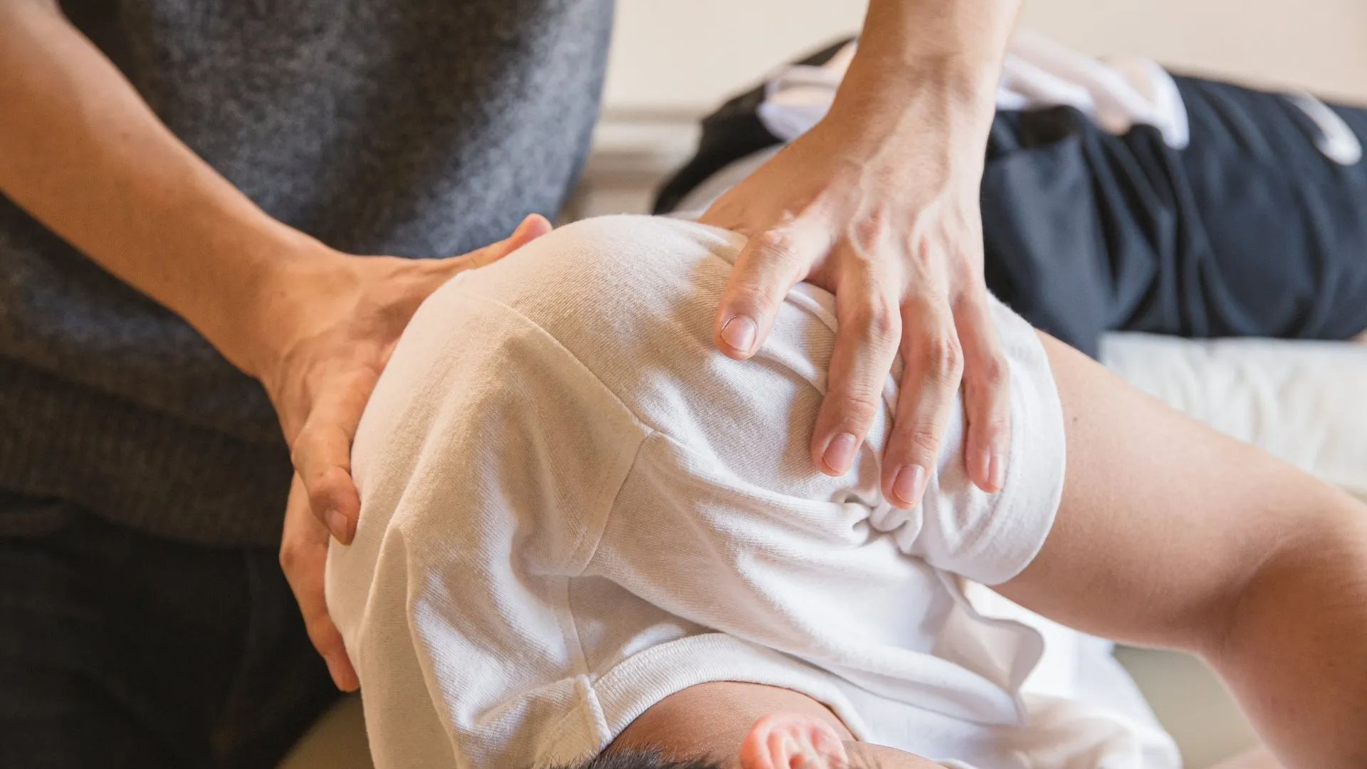 A person is laying on a bed getting an Osteopathy massage.