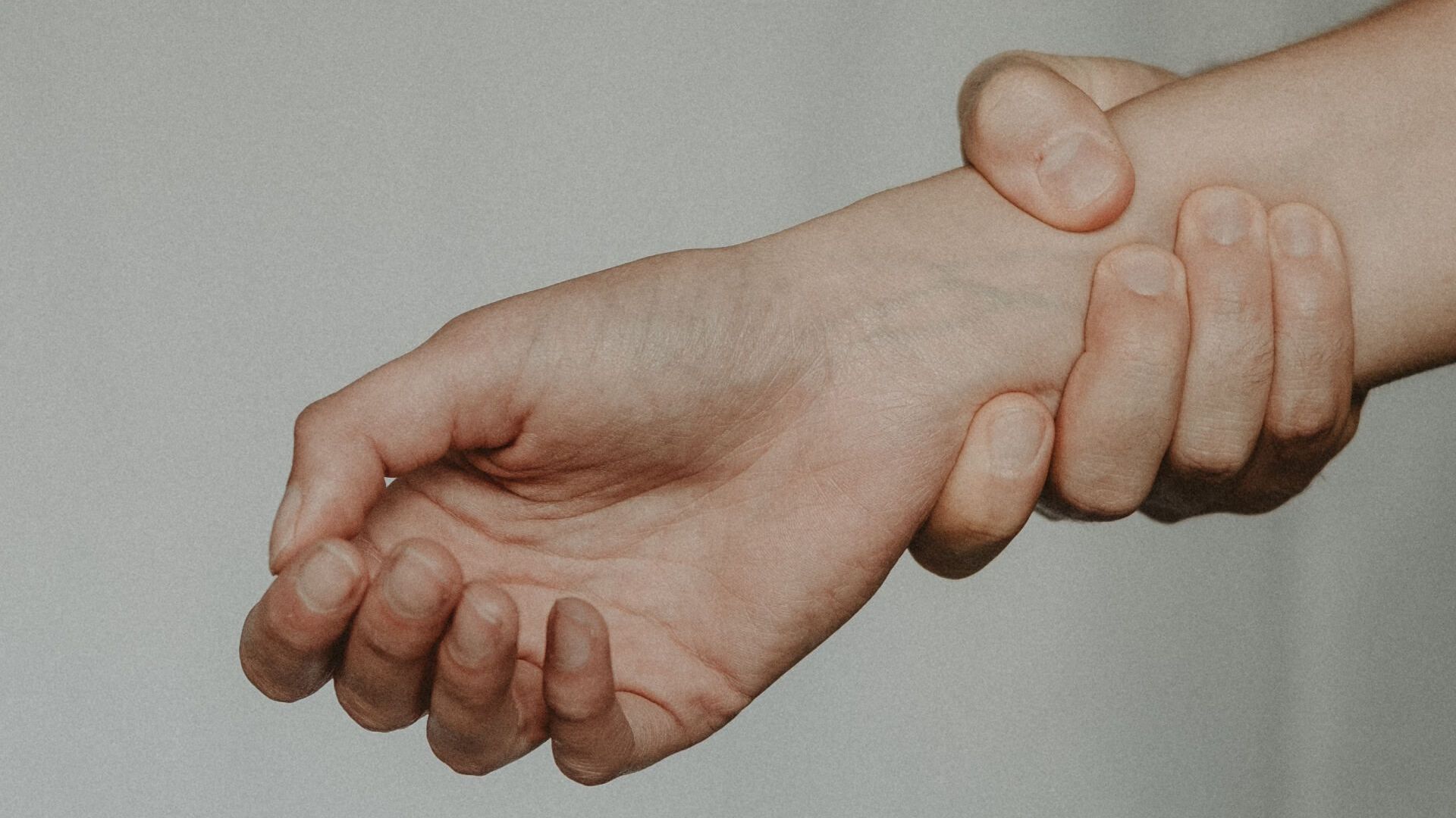 A person is holding their wrist in pain - carpal tunnel.