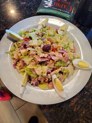 A white plate topped with a chef salad and eggs on a table