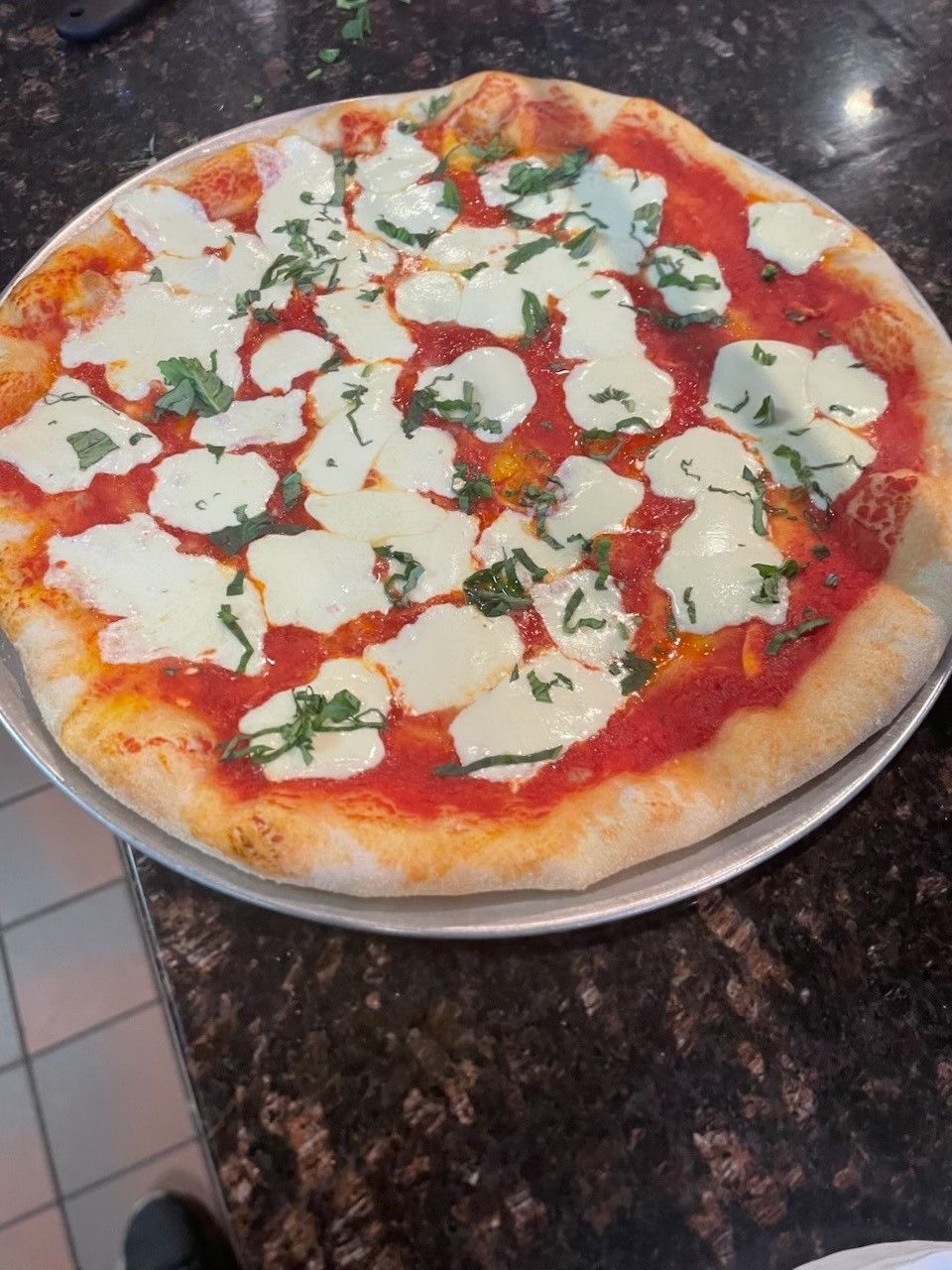 A margherita pizza on a counter