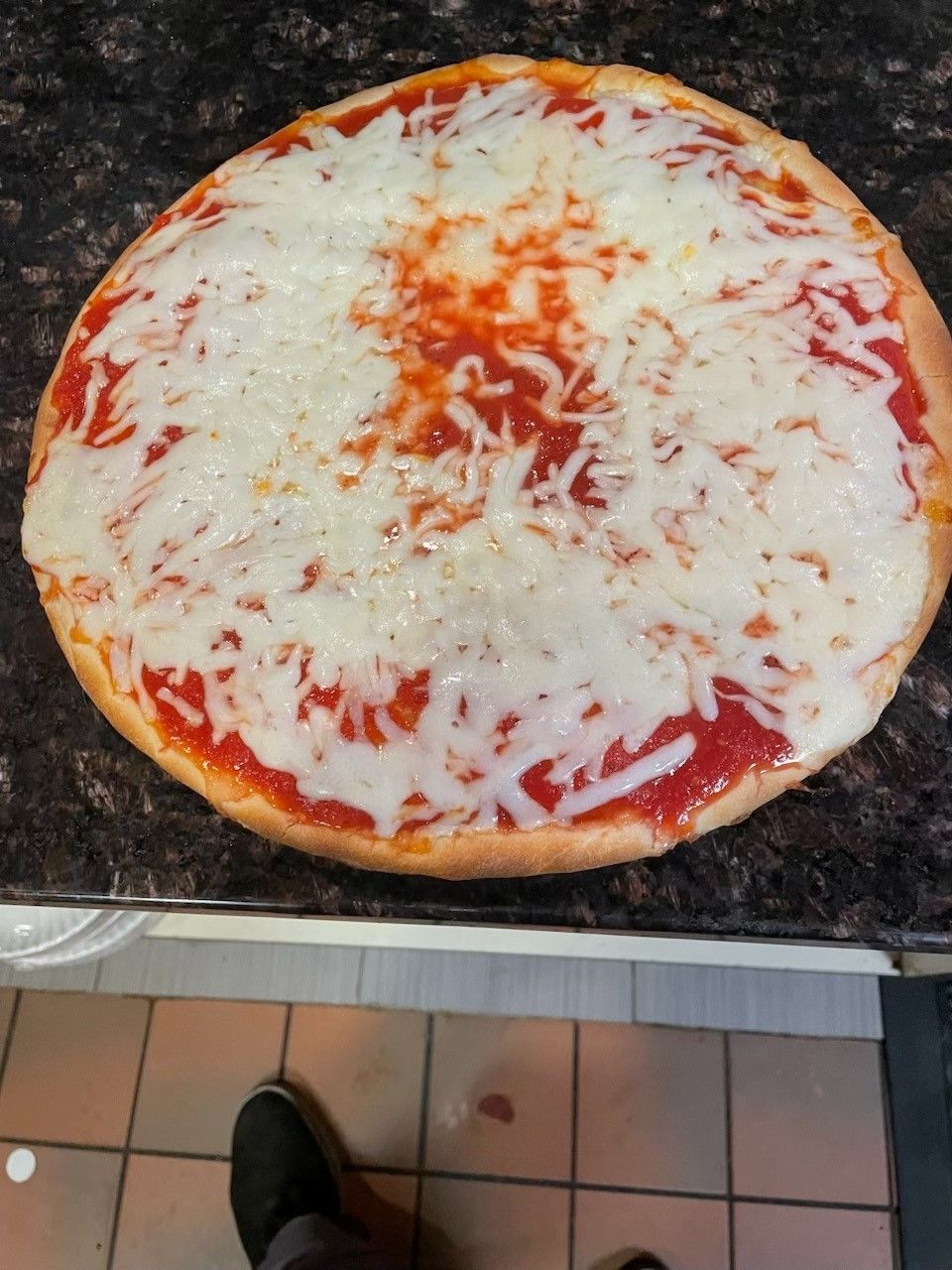 A cheese pizza is sitting in a cardboard box on a table