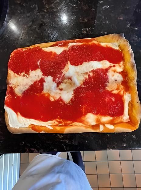 An upside down sicilian pizza sitting on the counter