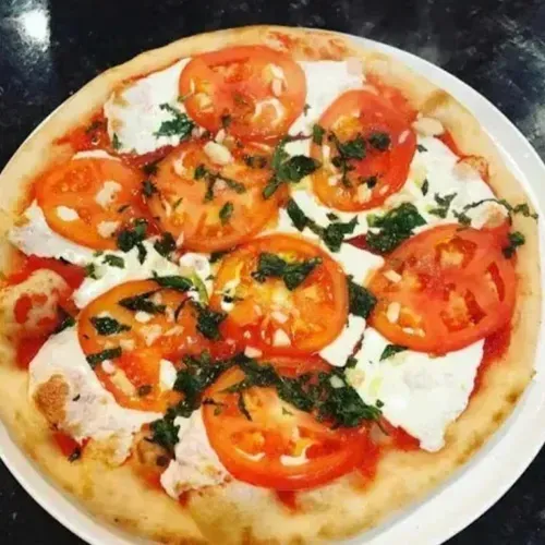 A caprese pizza on a white plate