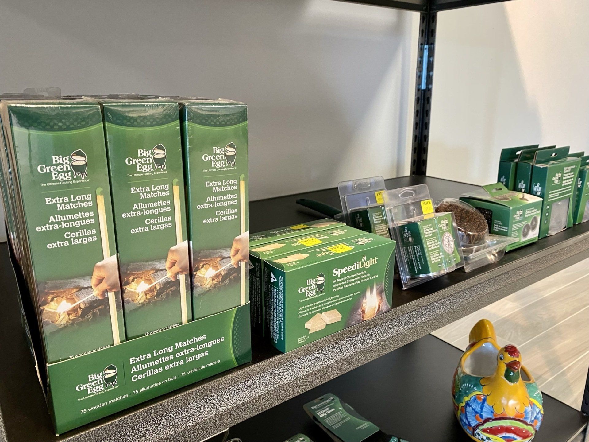 Shelves stocked with green boxes of food products; some with skewers and marshmallows.