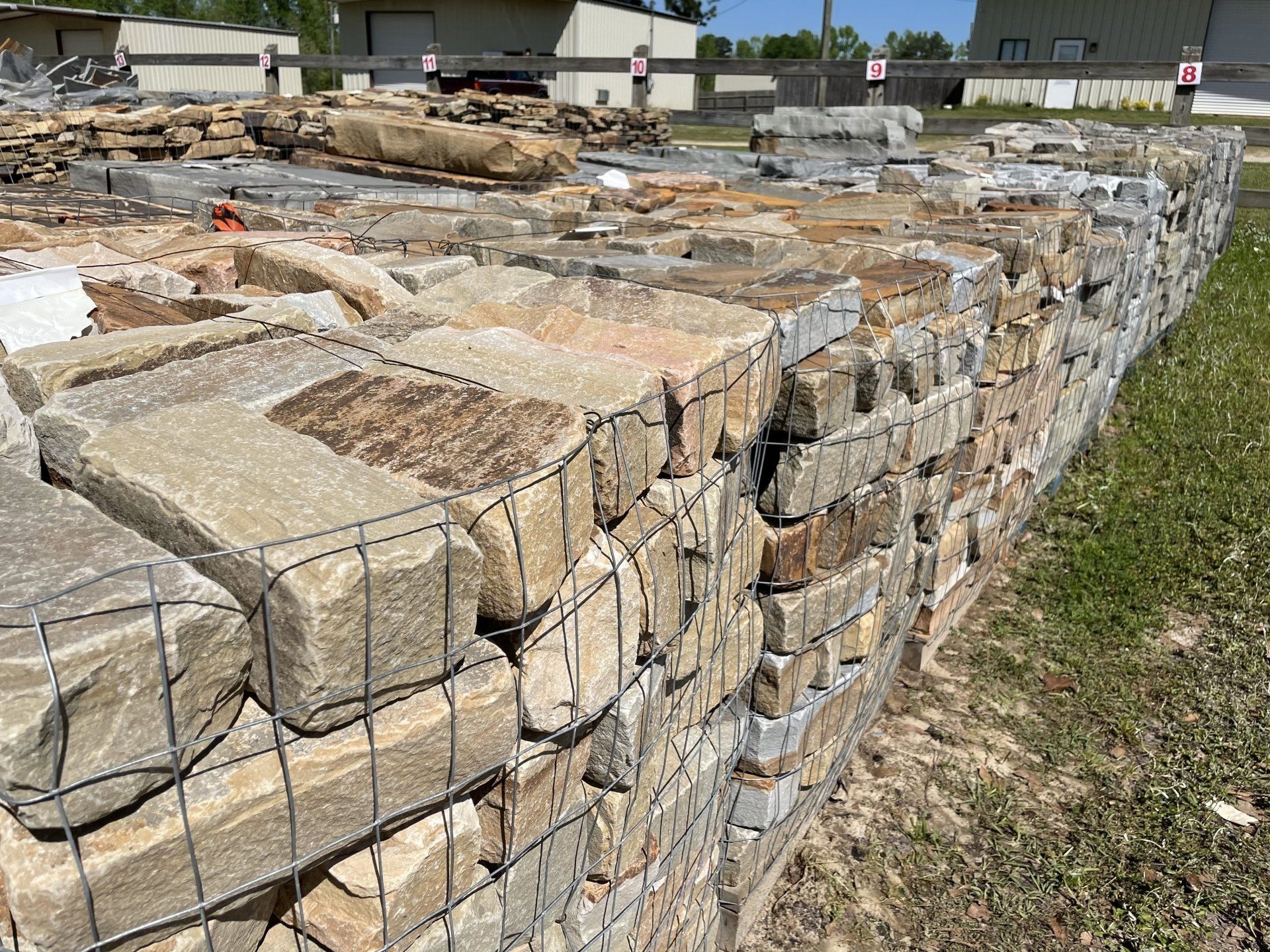 Stone blocks in wire cages form a retaining wall; more stones sit behind.