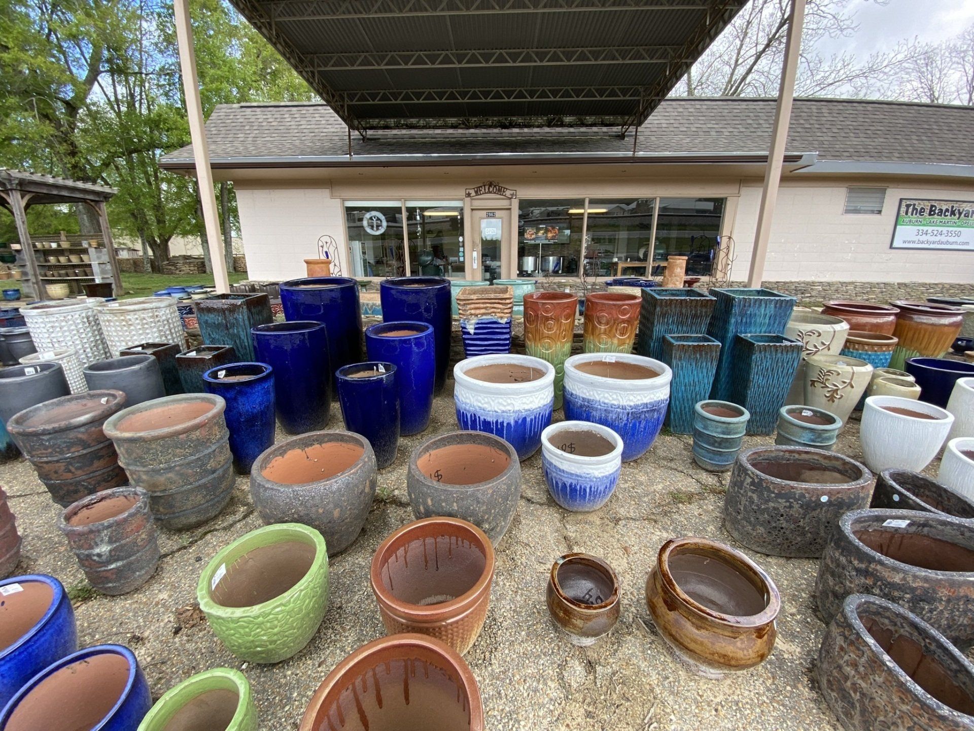 Various colorful ceramic flower pots displayed outside a garden center.