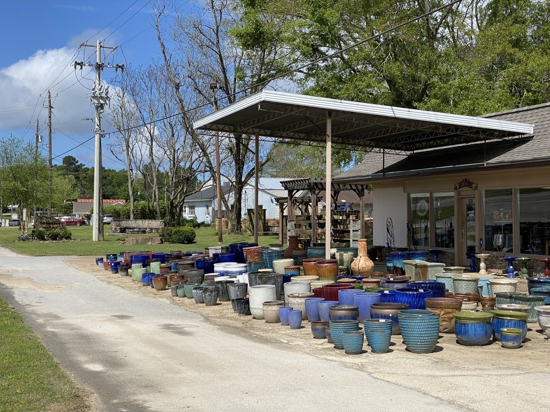 Pots and planters of various colors outside a building with a covered entrance.