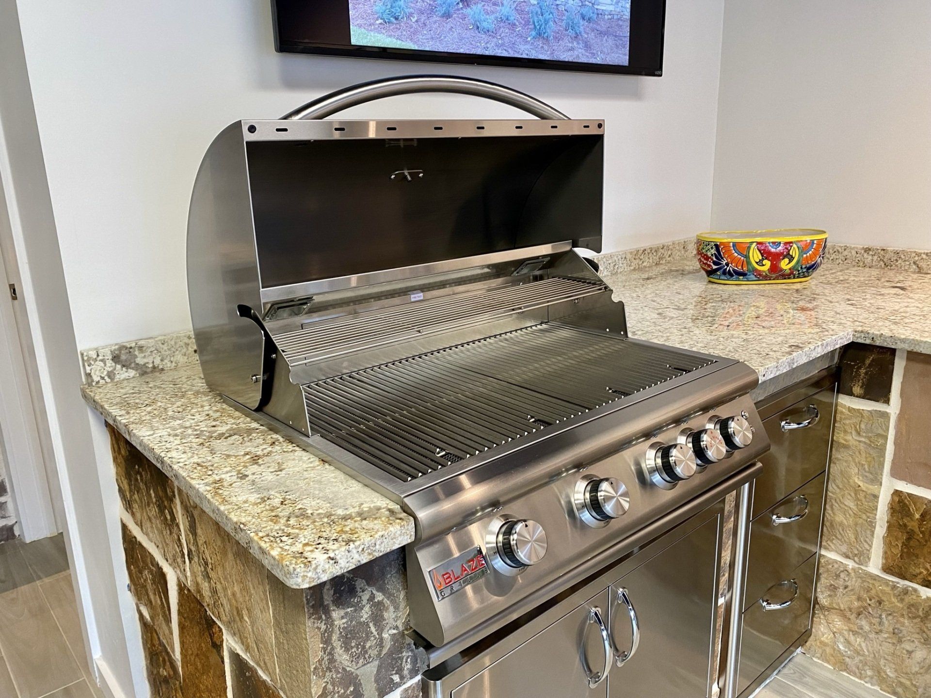 Stainless steel outdoor grill on granite countertop.