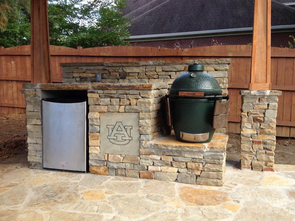 A green egg sitting on top of a stone patio