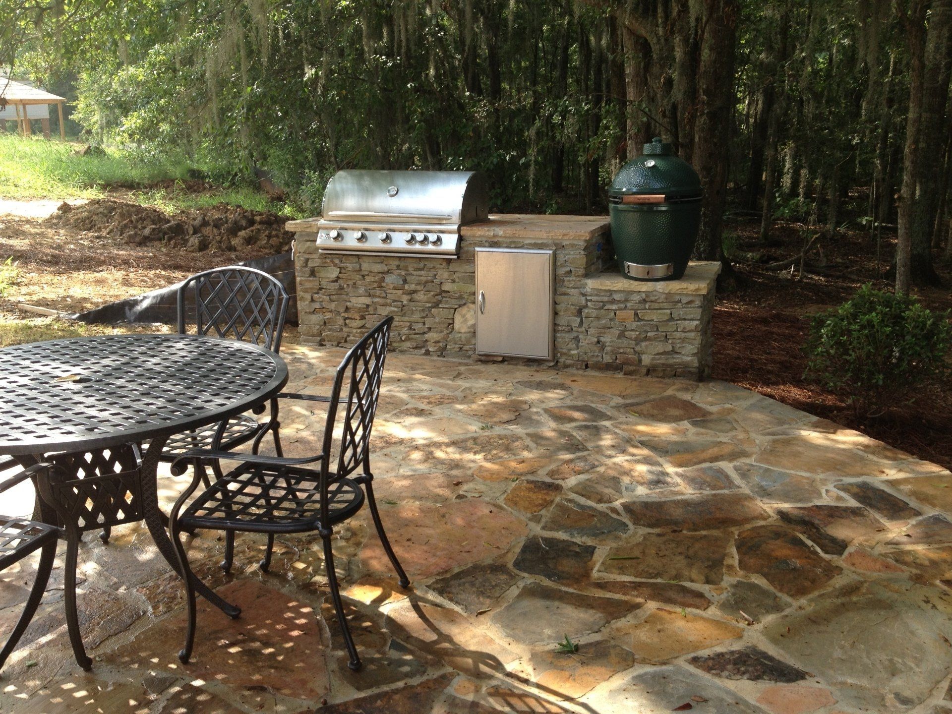 A patio with a table and chairs and a grill