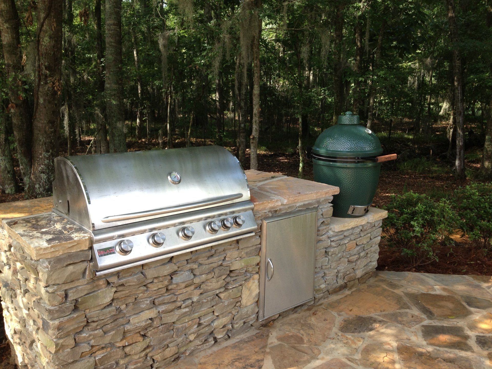 A stainless steel grill is sitting on top of a stone counter.