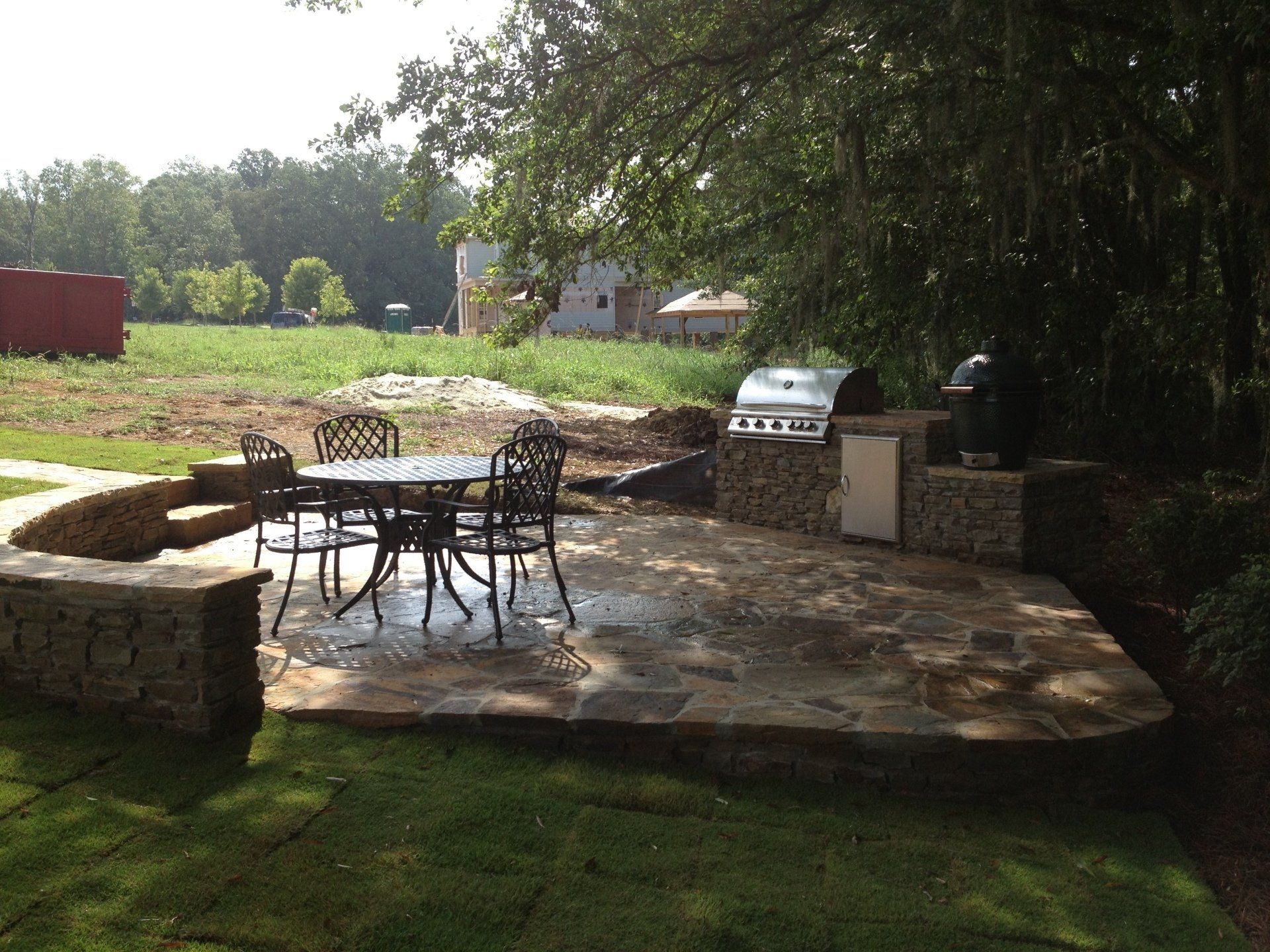 A patio with a table and chairs and a grill