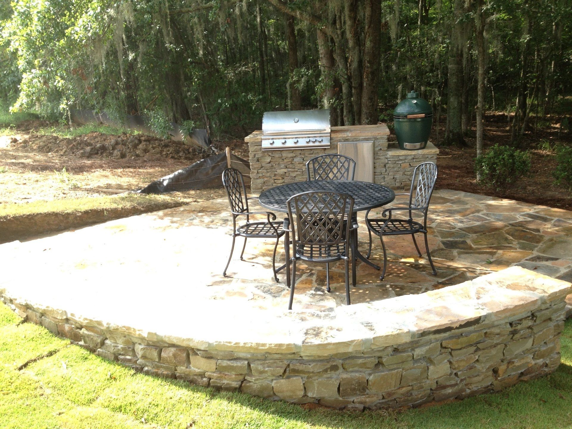 A patio with a table and chairs and a grill