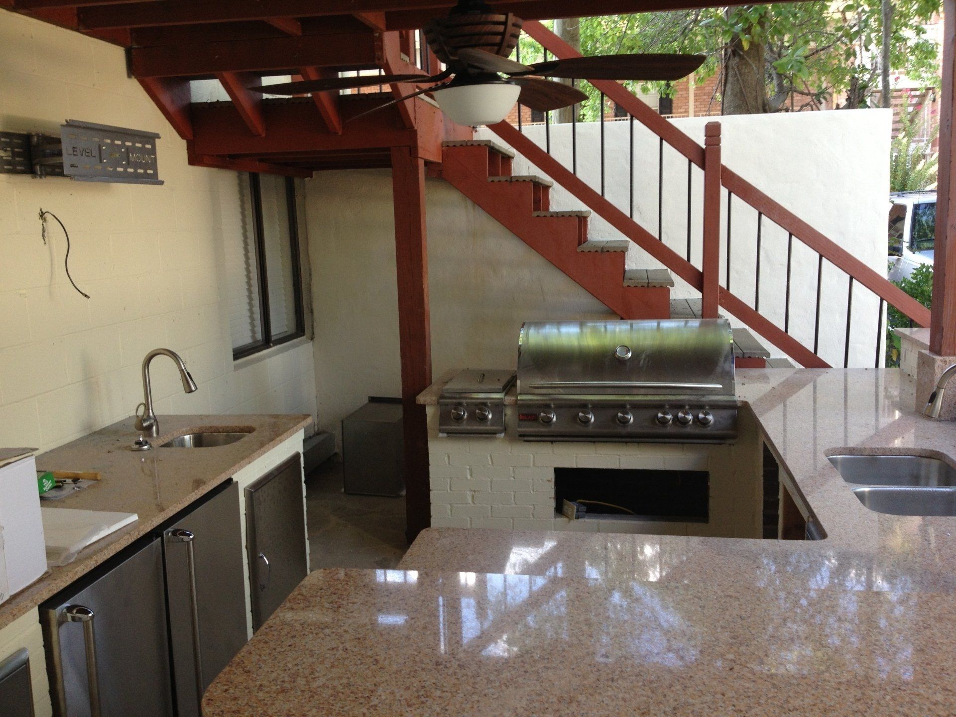 A kitchen with a ceiling fan and stairs in the background
