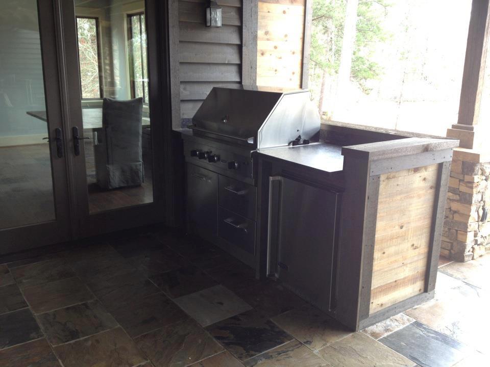 An outdoor kitchen with a grill and a sink