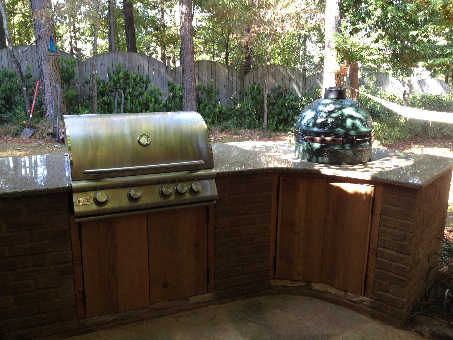 An outdoor kitchen with a grill and a pizza oven