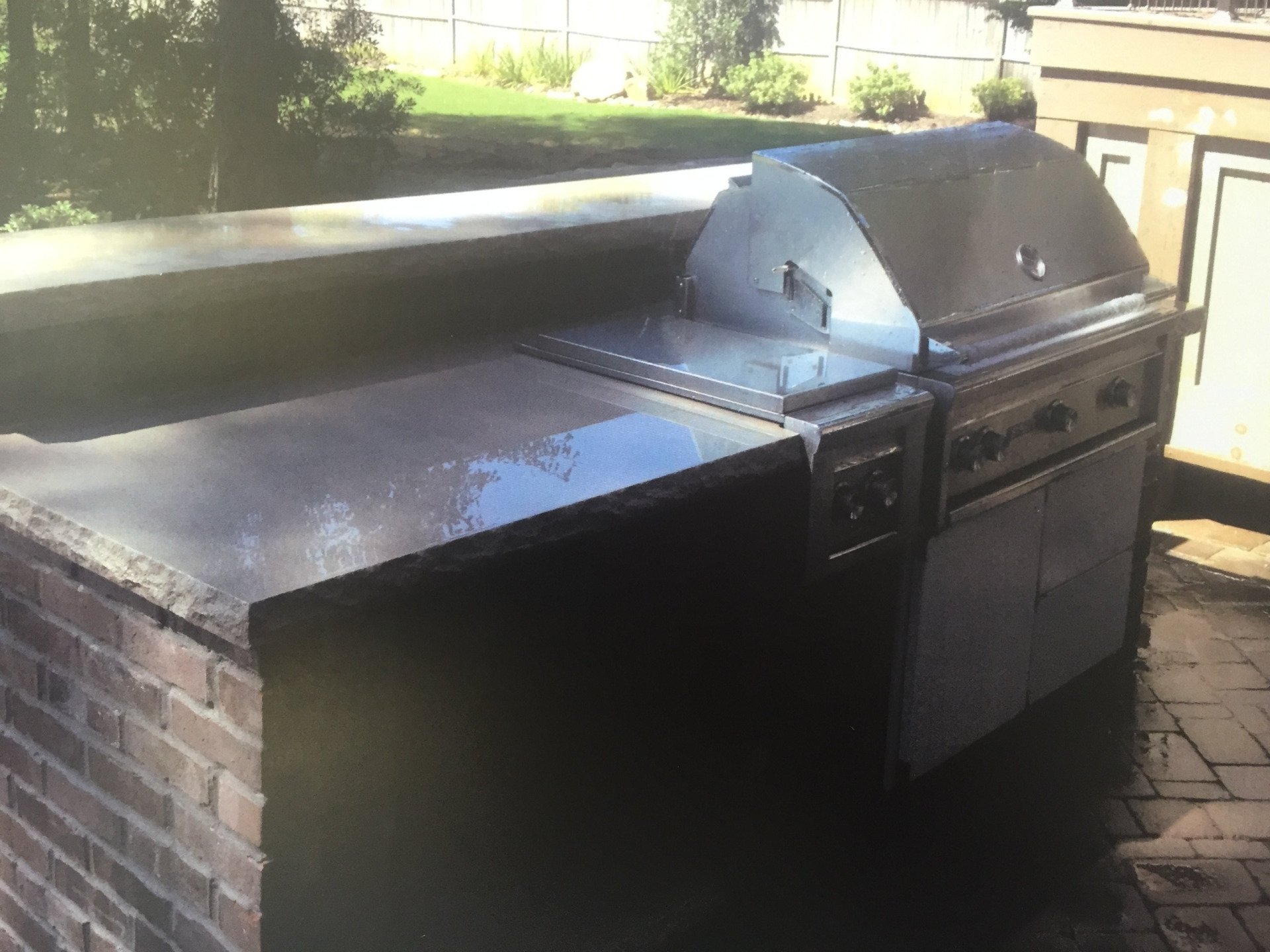 A grill is sitting on top of a brick counter.