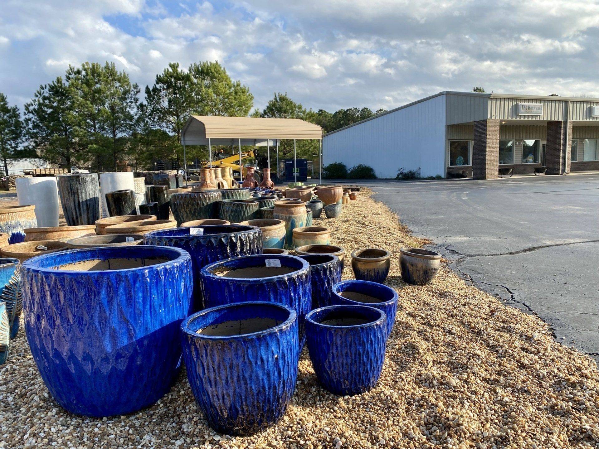 A bunch of blue pots are sitting on the ground in front of a building.