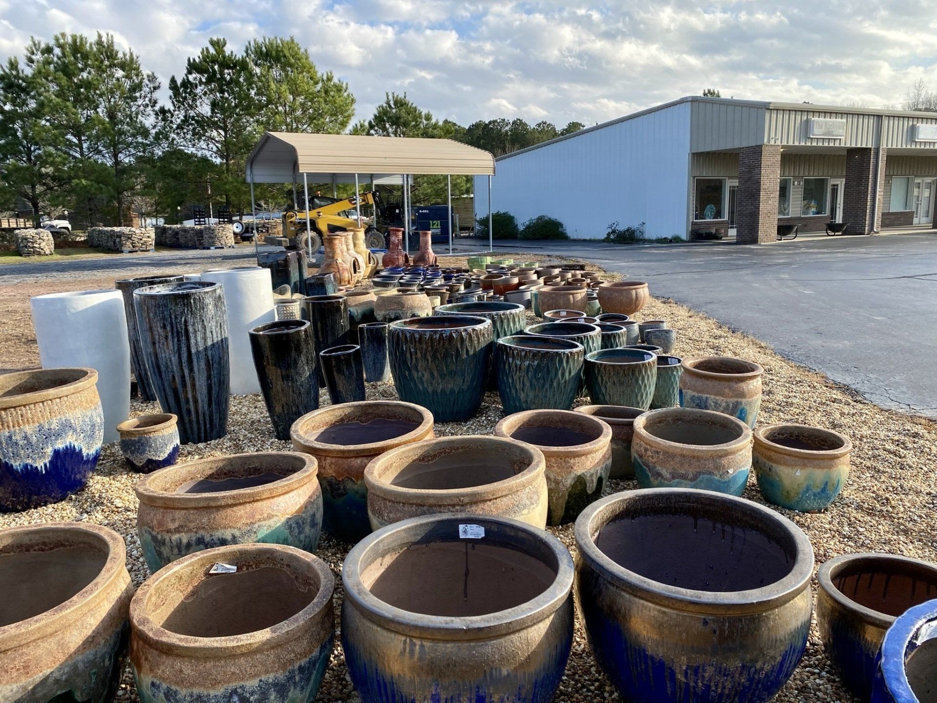 A bunch of pots are sitting on the ground in front of a building.