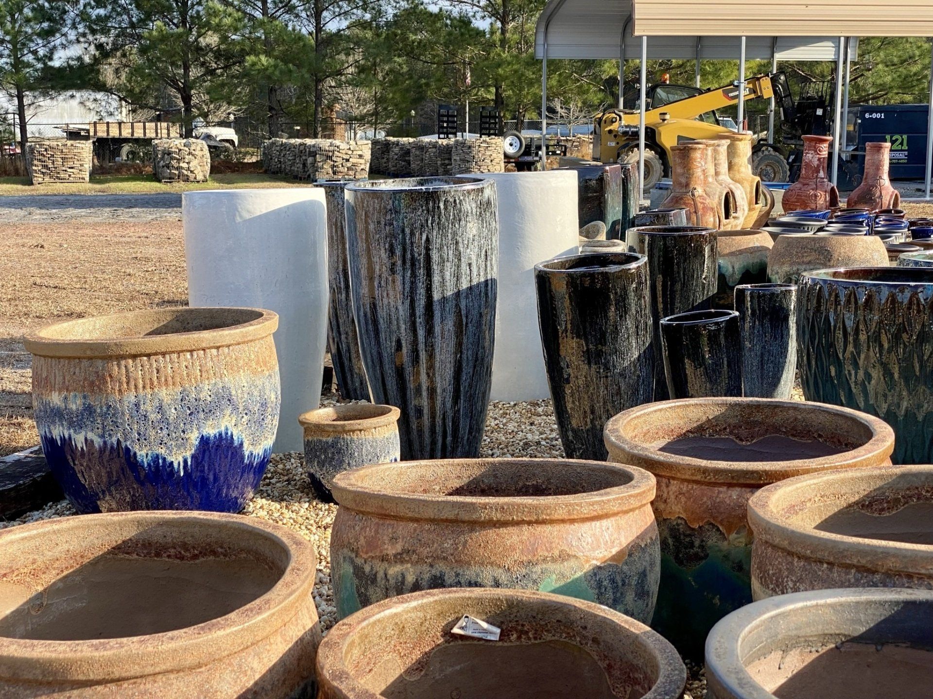 A bunch of pots are sitting on top of each other in a field.