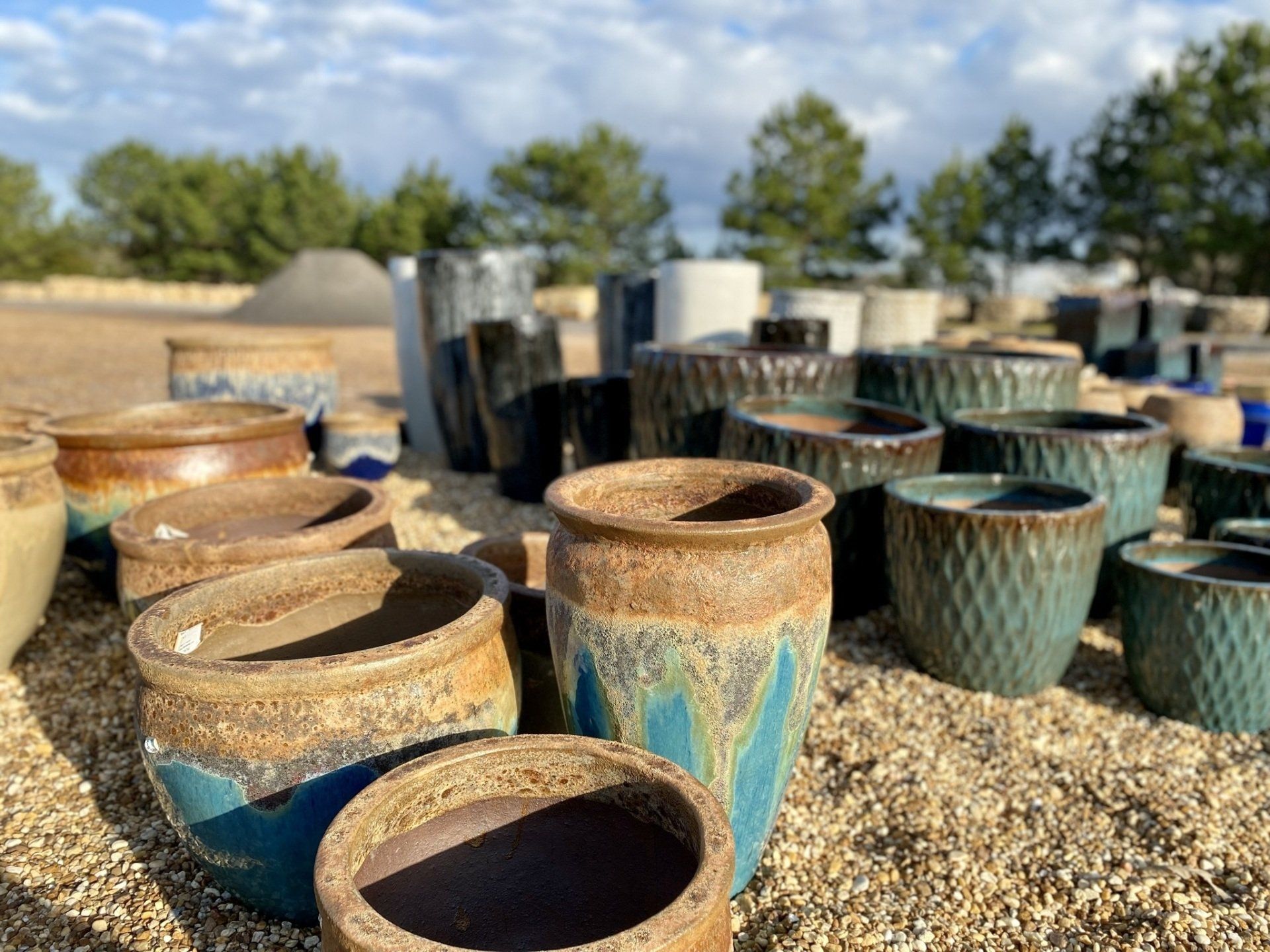 A bunch of pots are sitting on top of a pile of gravel.