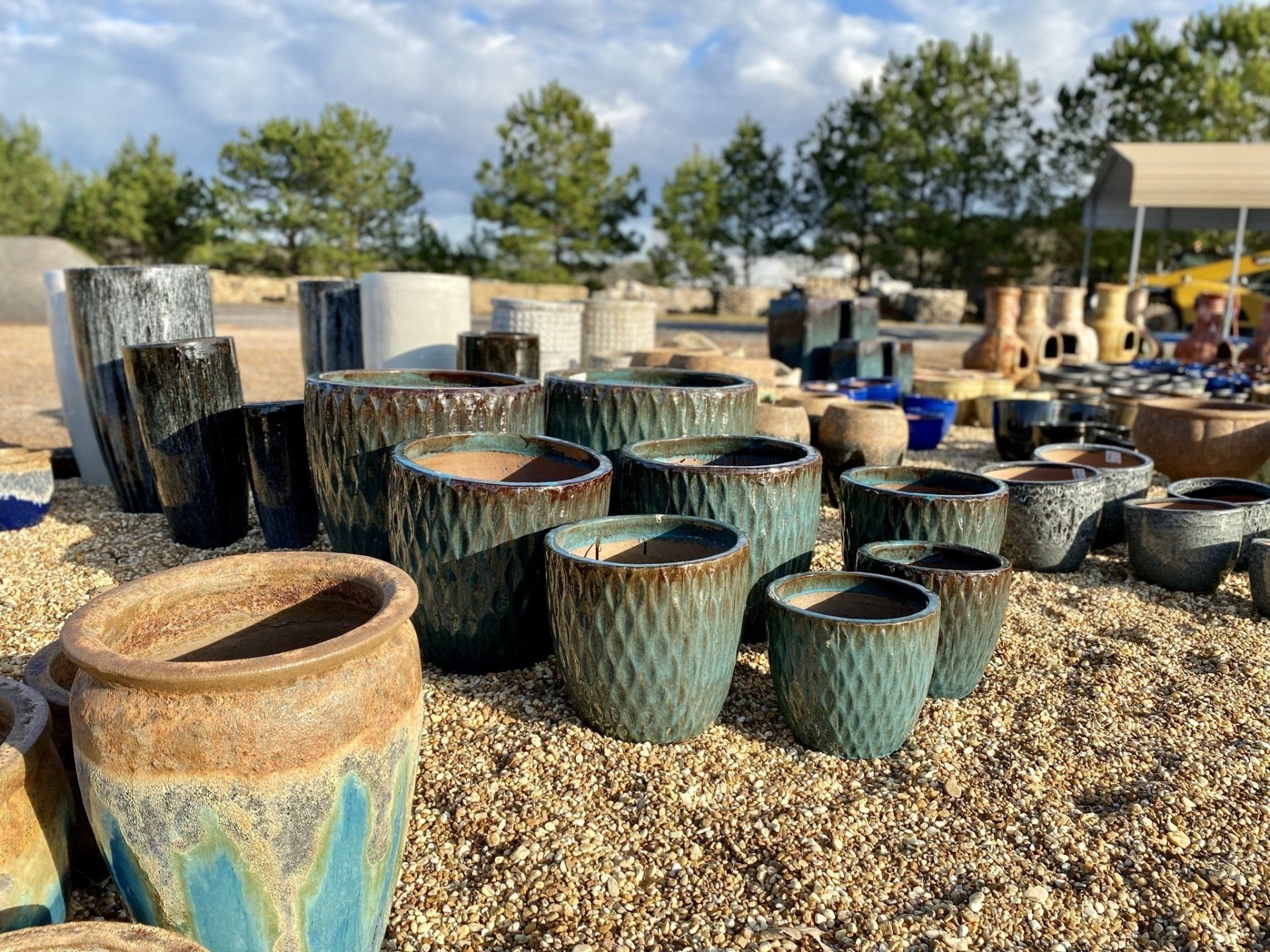 A bunch of pots are sitting on top of a pile of gravel.