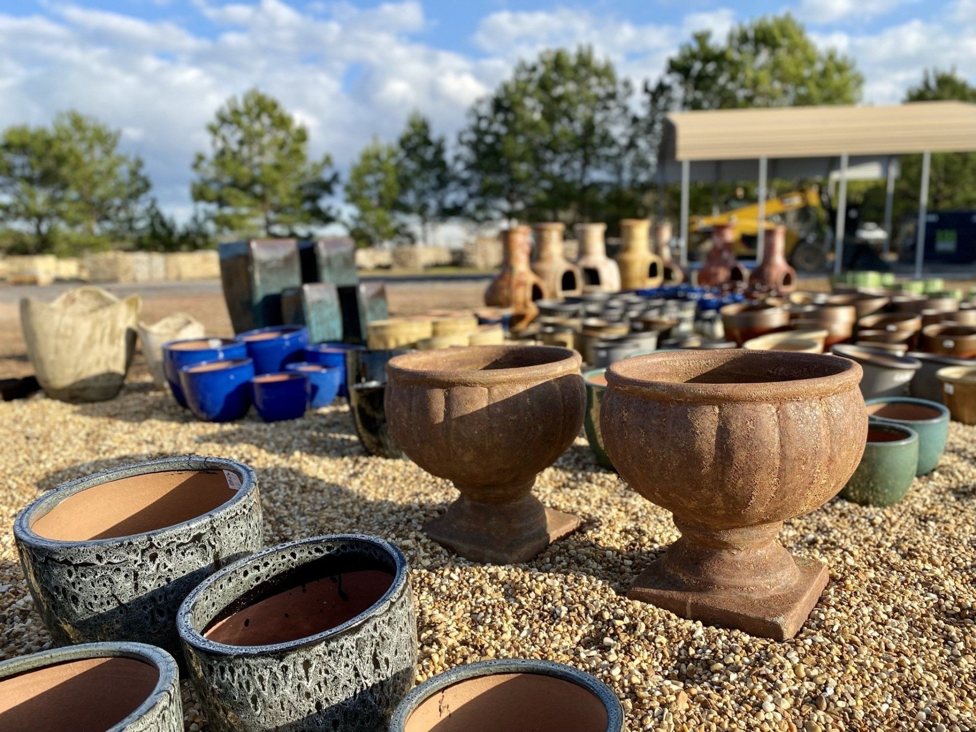 A bunch of pots are sitting on top of a pile of gravel.