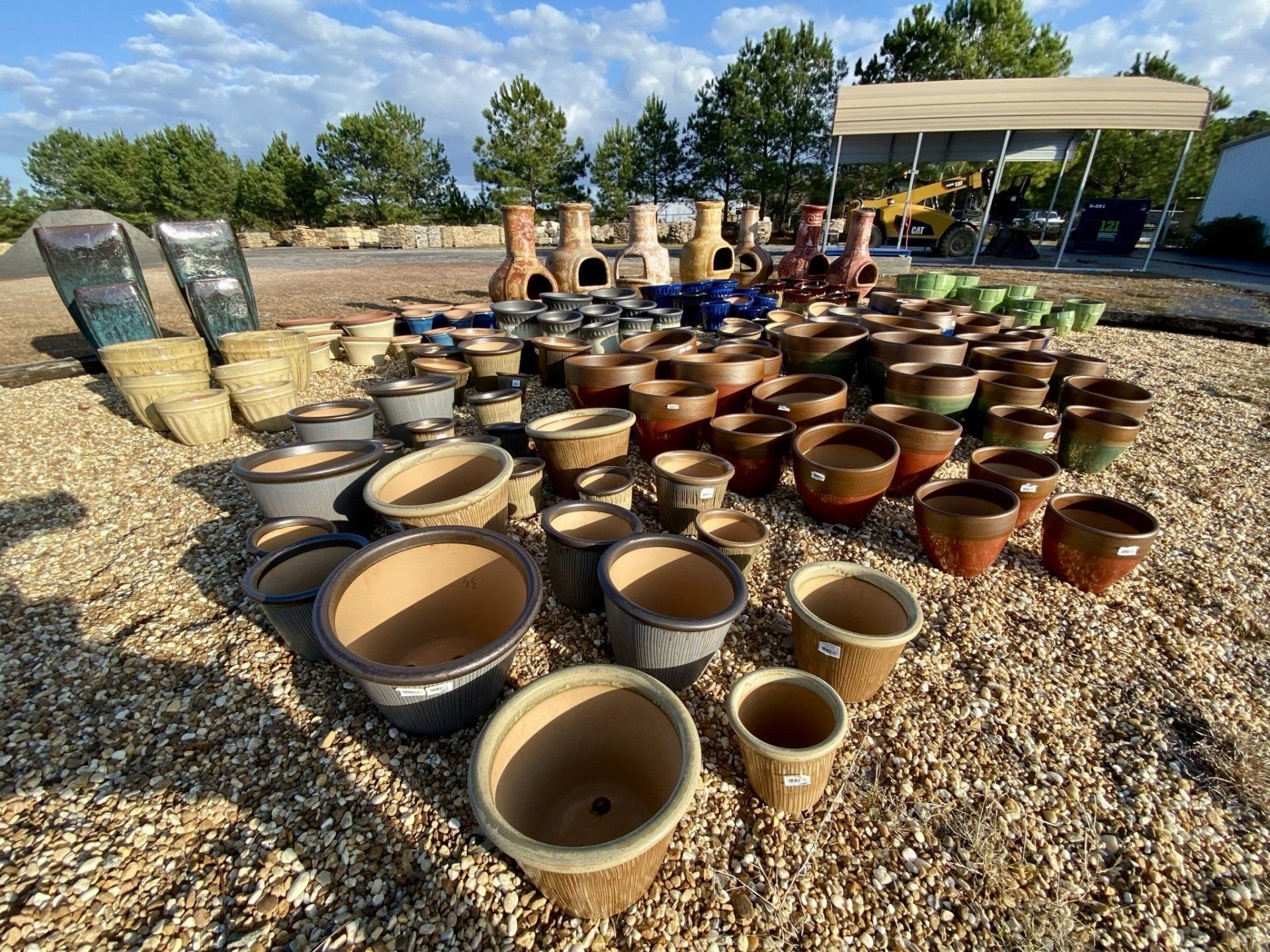 A bunch of pots are sitting on top of a pile of gravel.