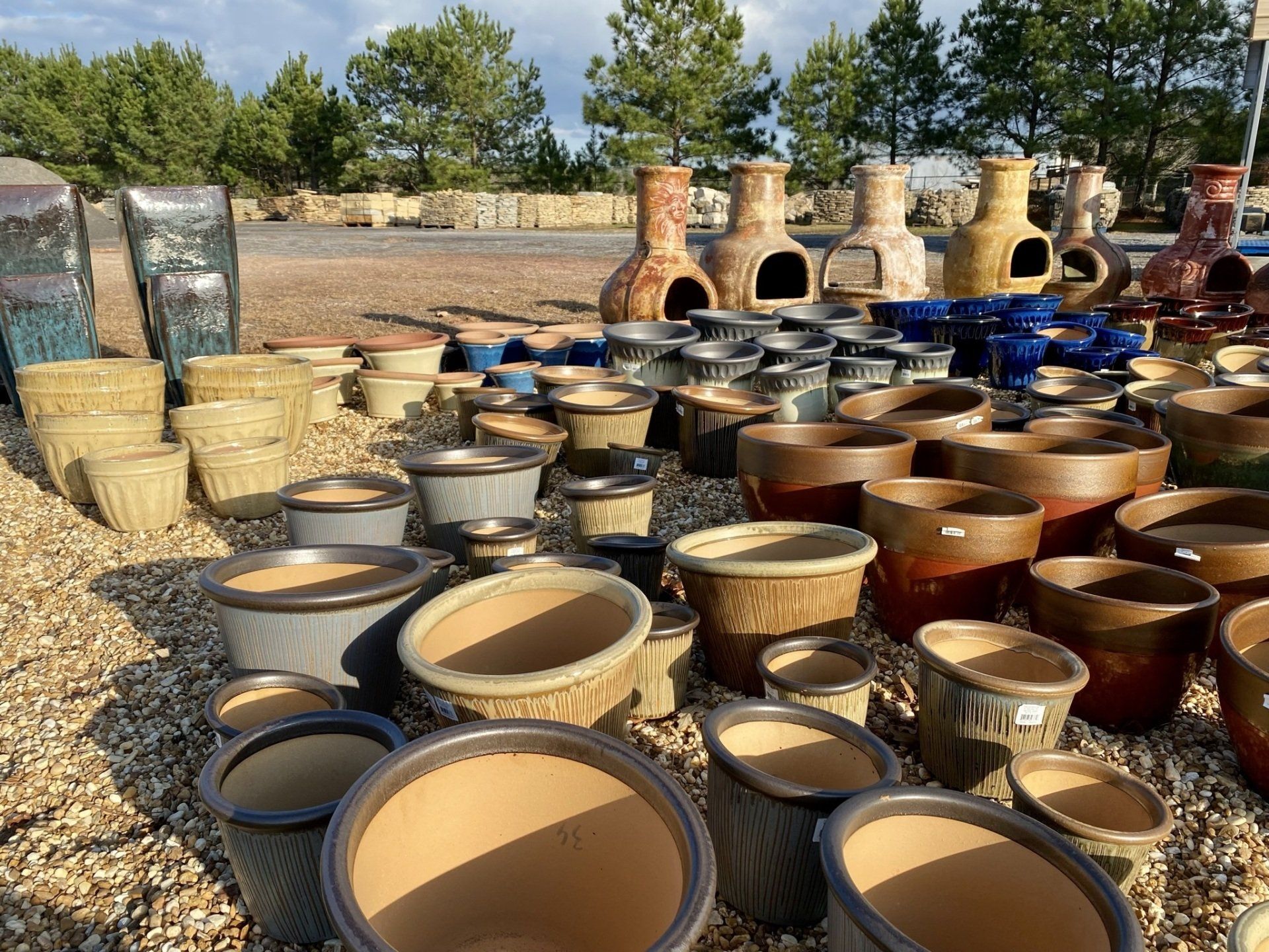 A bunch of pots are sitting on a pile of gravel.