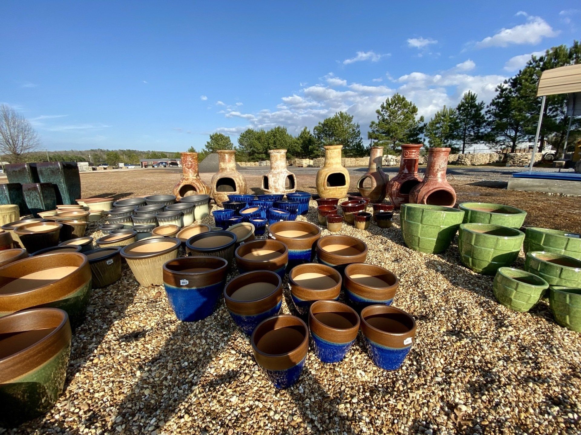 A bunch of pots are sitting on top of a pile of gravel.