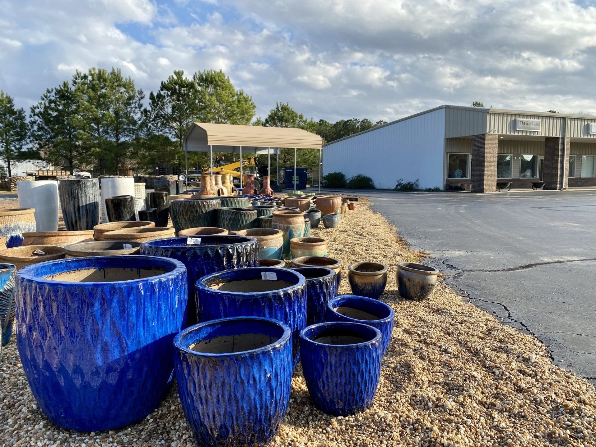 Blue ceramic pots on display outside a garden supply store.