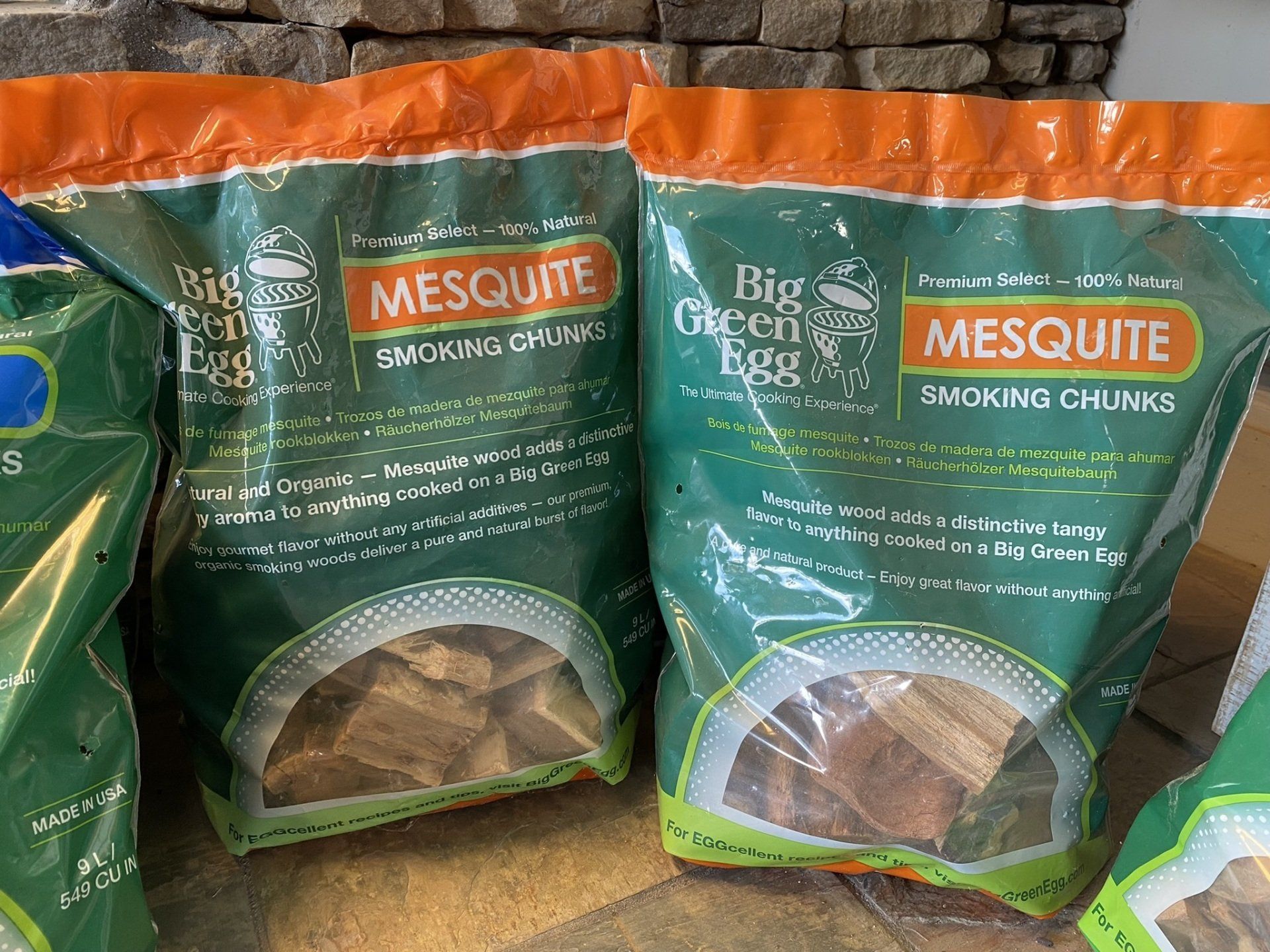 Three bags of mesquite wood chips are sitting on a table.