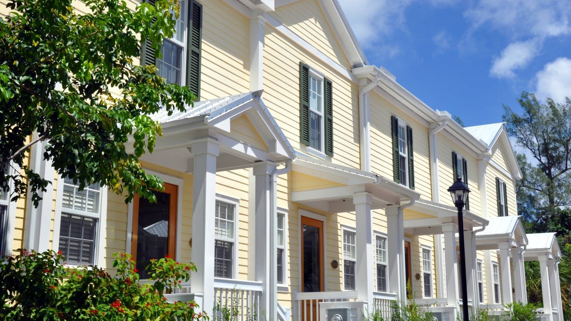A row of yellow and white houses with black shutters