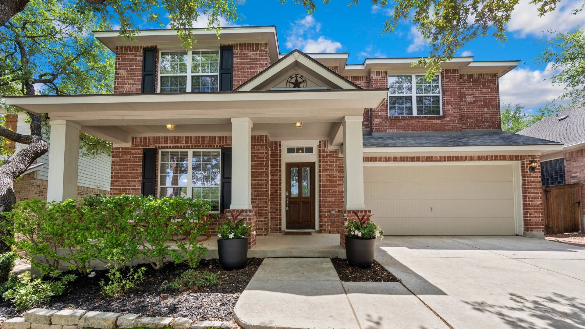 A large brick house with a white garage door and a porch.