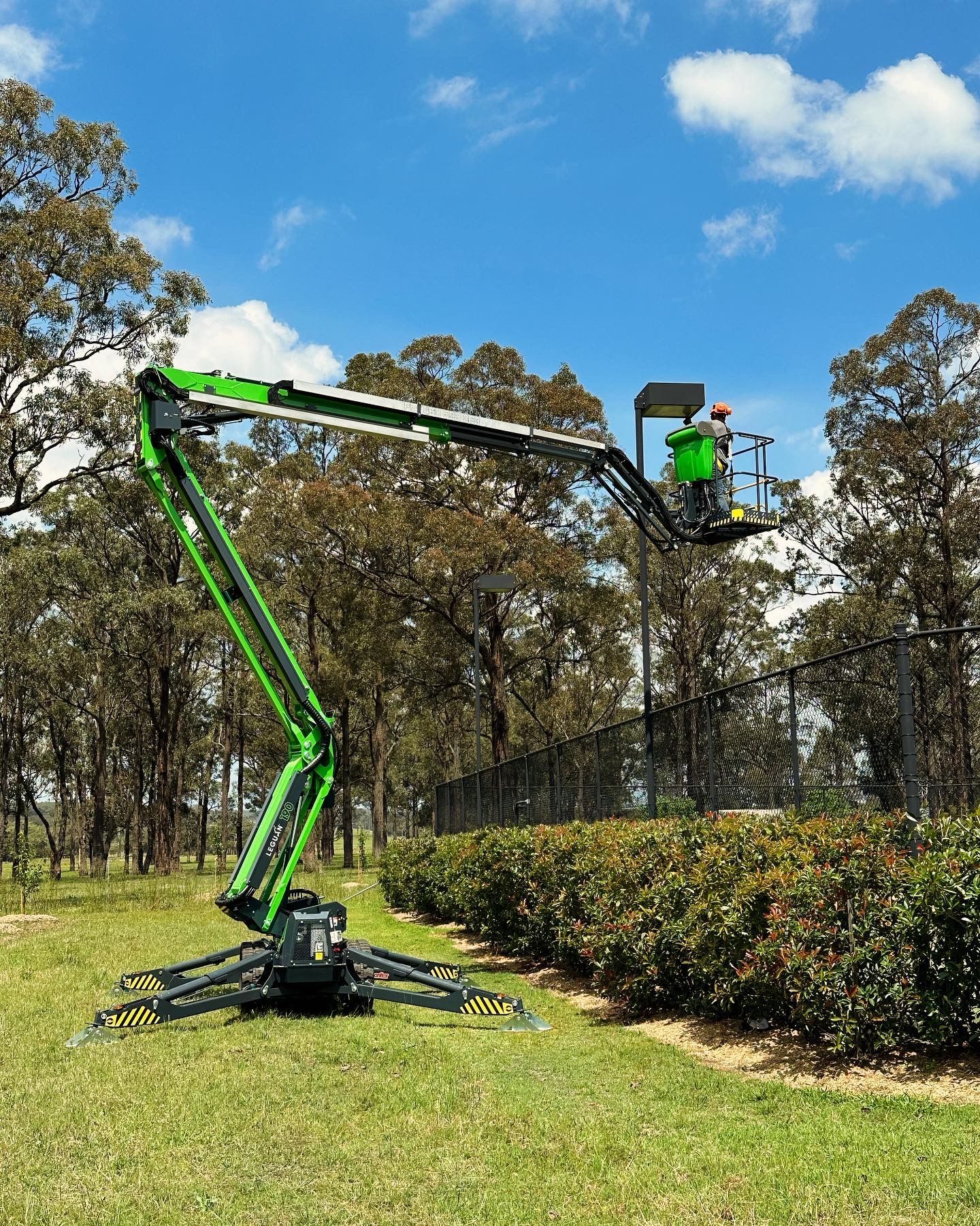 Wheeled Scissor Lift Working On A Light Post — High Work Services in Newcastle, NSW