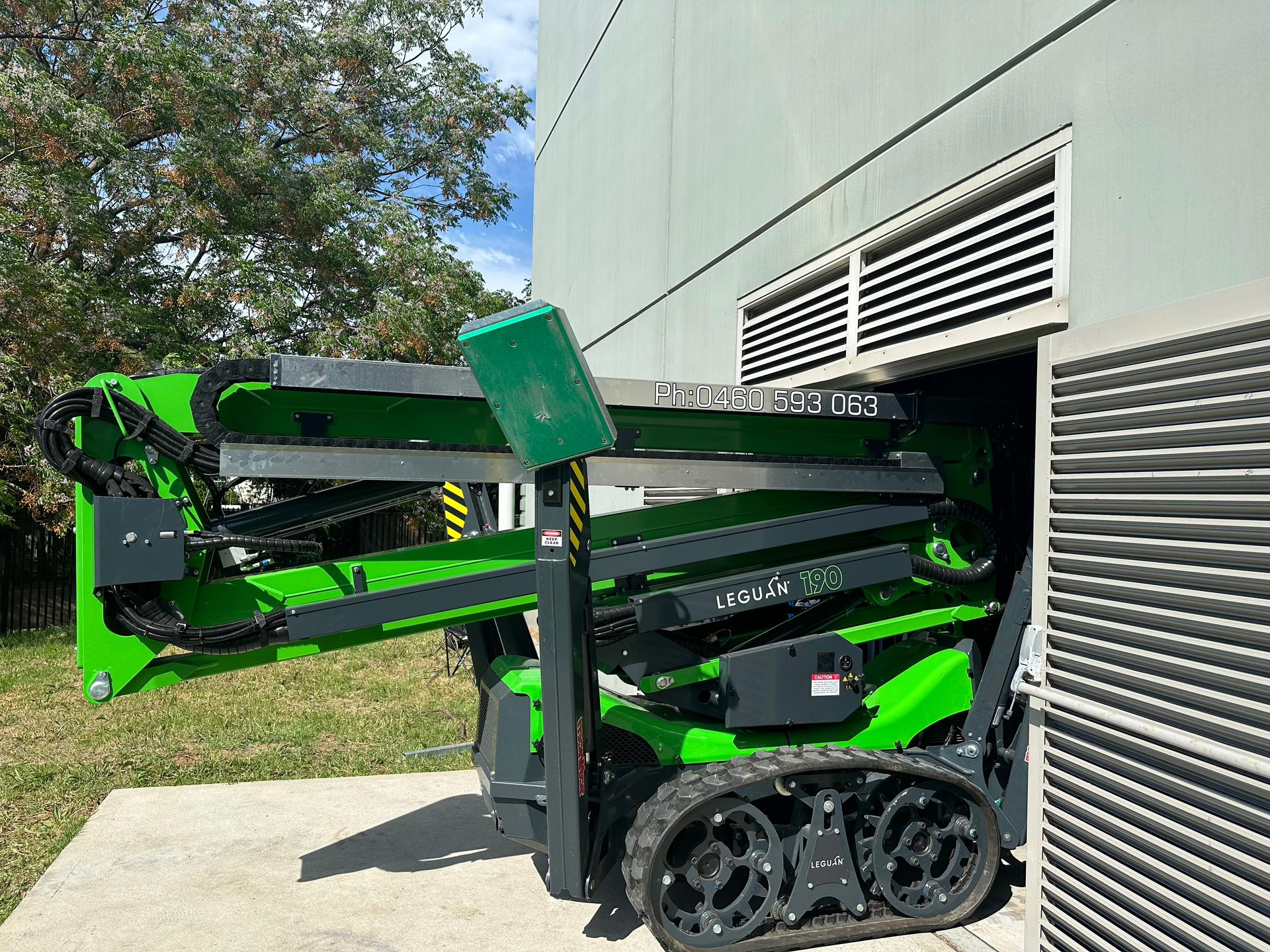 A Green Aerial Lift In A Yard — High Work Services in Hunter Valley, NSW