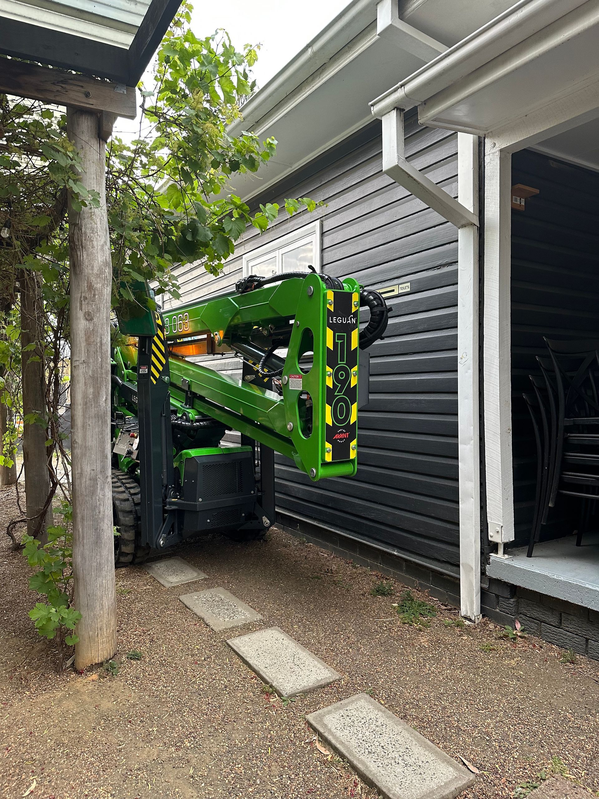 Green Crane Parked in a Garden — High Work Services In Cessnock, NSW