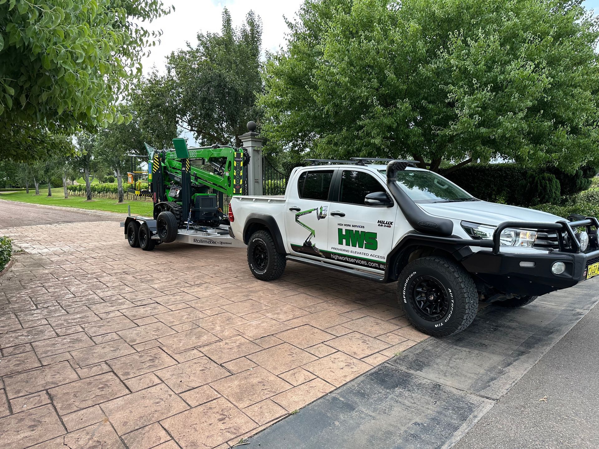 A Row Of Scissor Lifts Are Parked In A Warehouse — High Work Services in Maitland, NSW