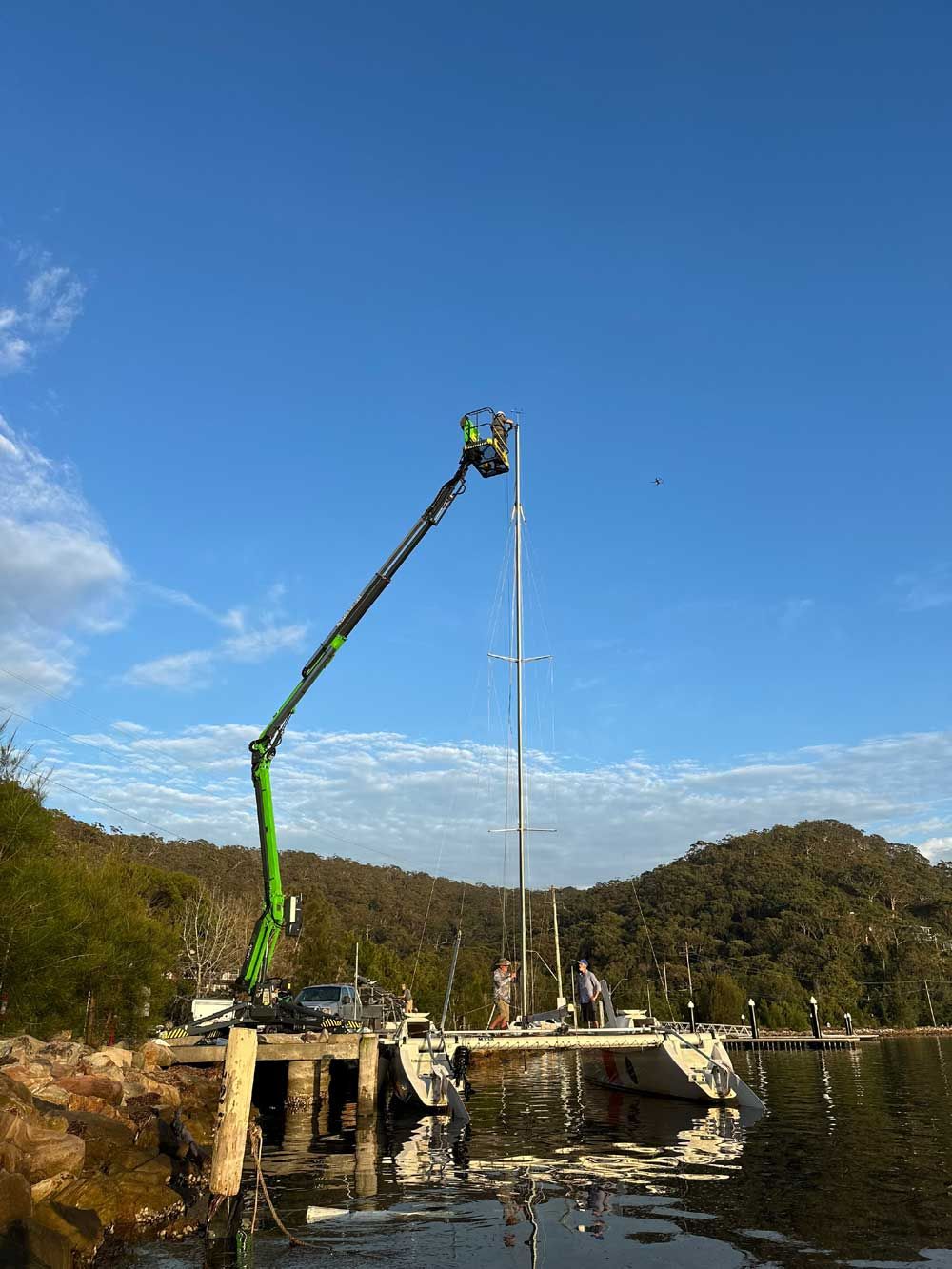 A Green Crane Is Working On A Bridge Over A Body Of Water — High Work Services in Hunter Valley, NSW
