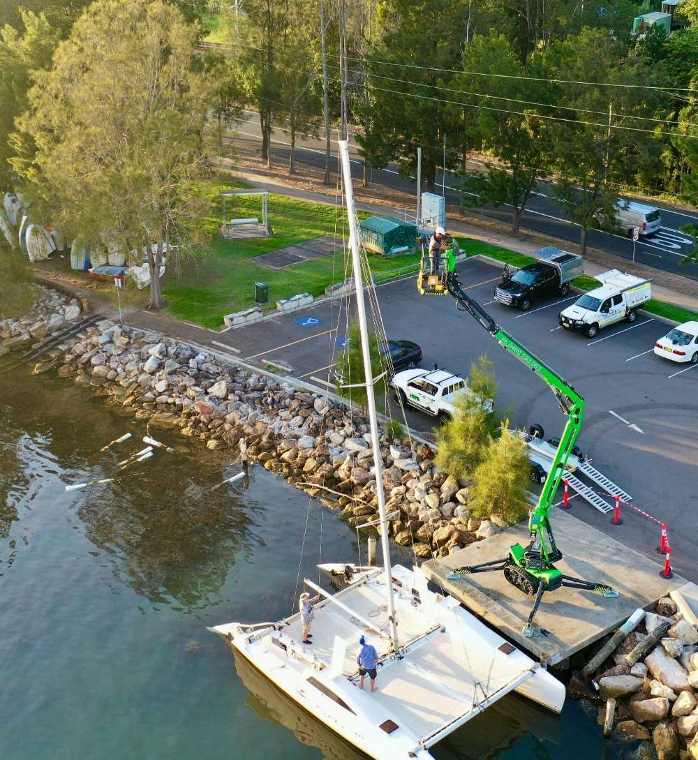 An Aerial View Of A Boat In The Water Next To A Crane — High Work Services in Maitland, NSW