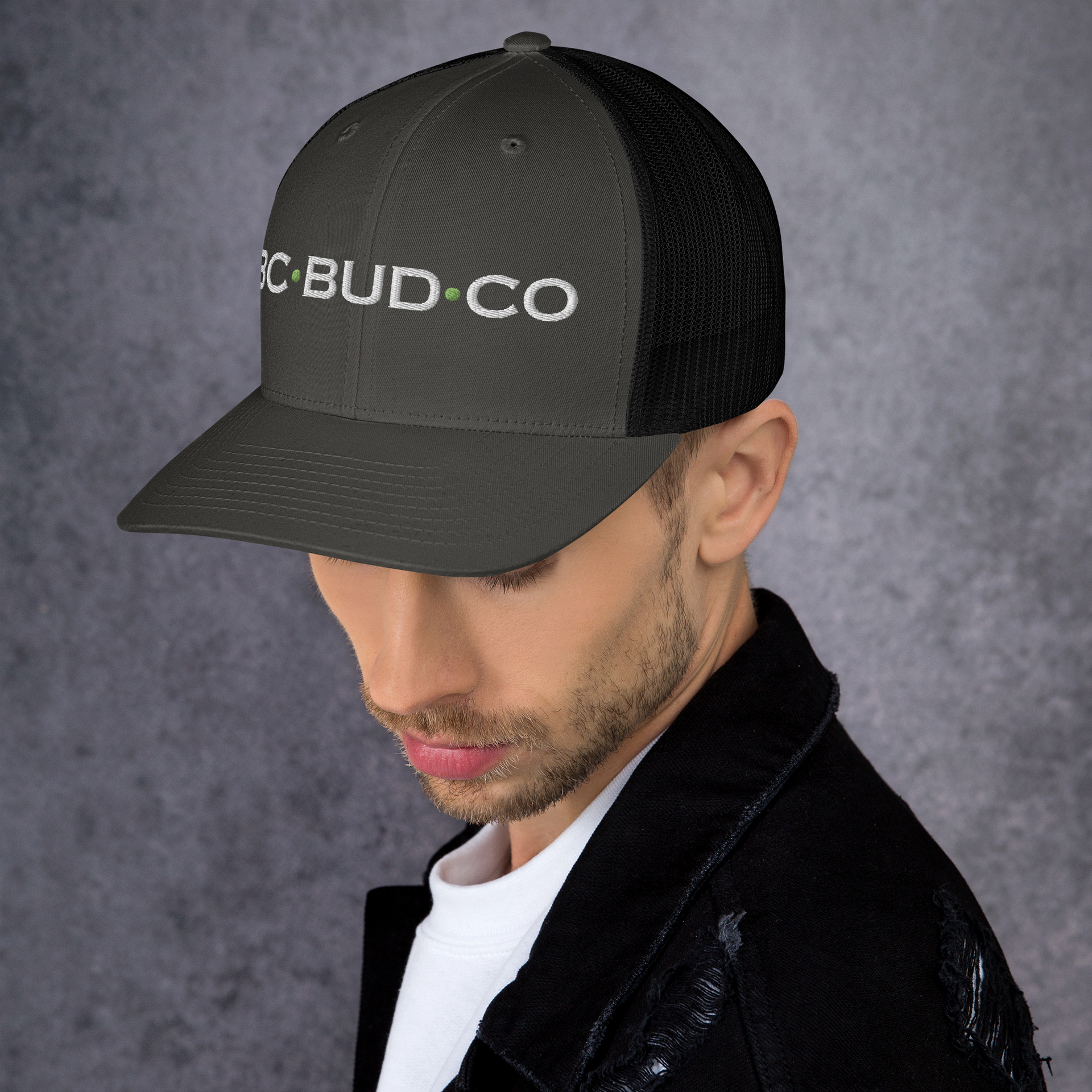A man wearing a black trucker hat that says bud co