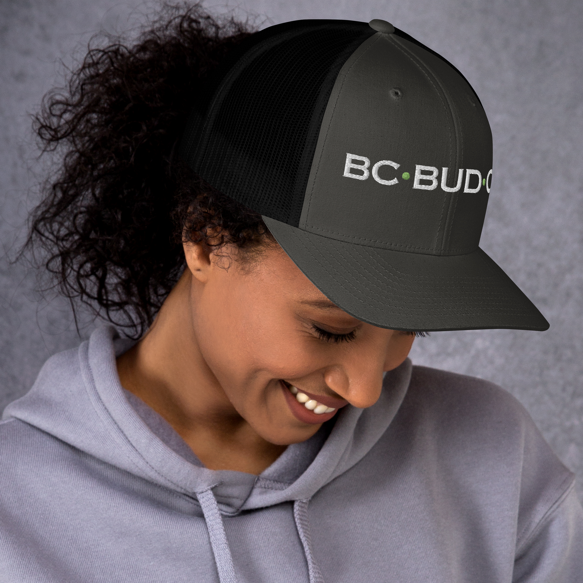 A woman wearing a hat that says bc bud